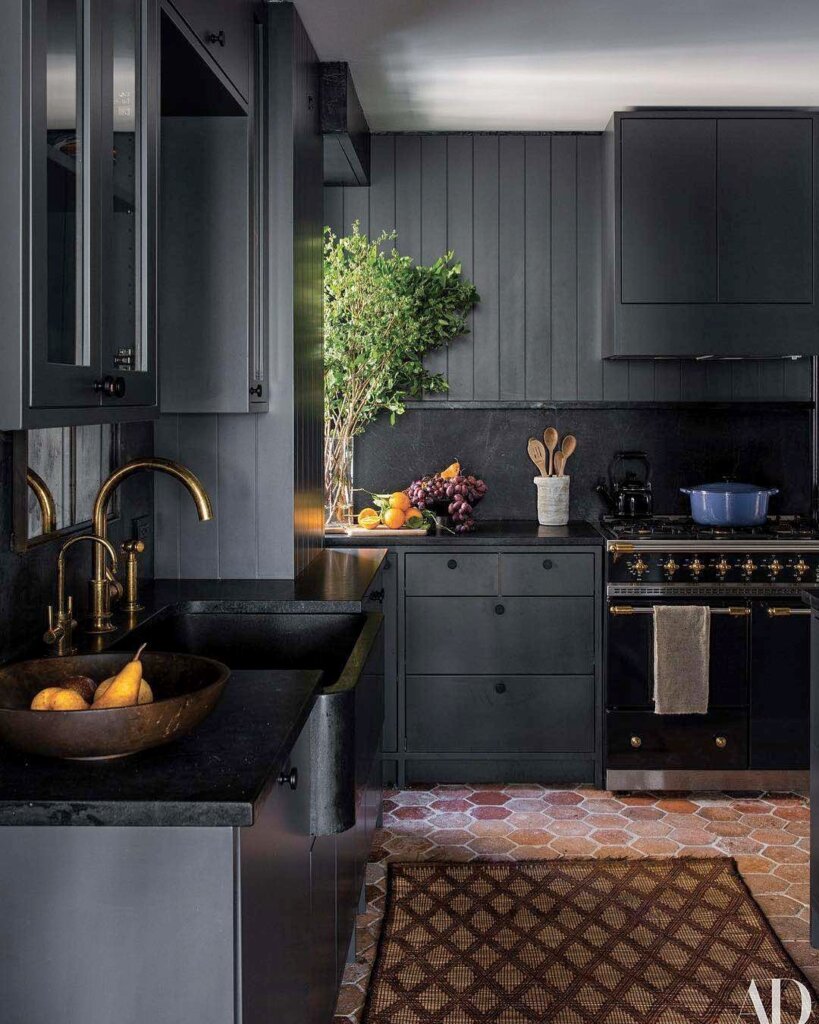 Modern kitchen with cabinetry painted off-black and appliances in black. 