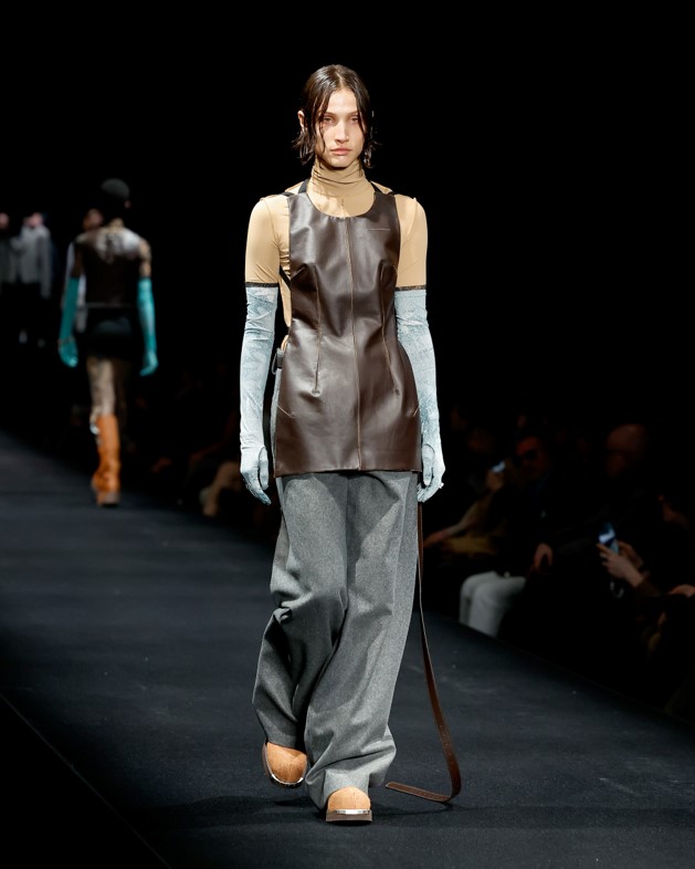 MM6 Welder's leather apron with baggy jeans and turtleneck in camel with full-length light blue gloves.