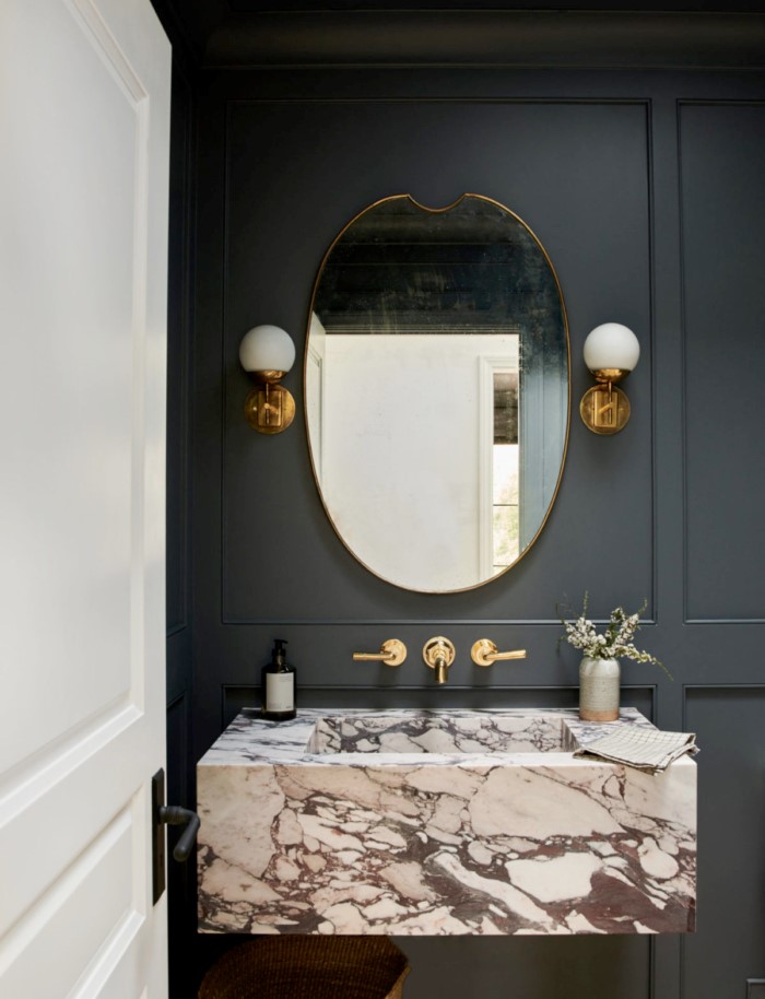 Powder room with Anchor Gray walls , marble basin and polished brass accents.