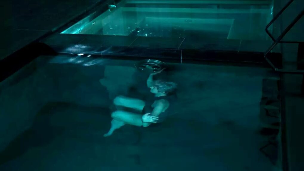 person under water in dark swimming pool