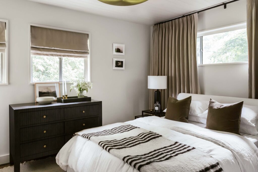 Full view of Guest Room 1 in neutral tones with contrasts of dark brown. 