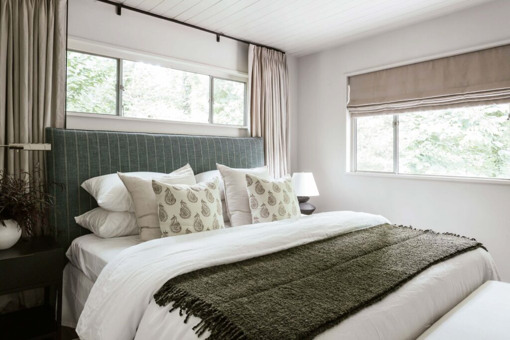 Guest room 2 bed with neutral tones accent with gray-blue fabric headboard