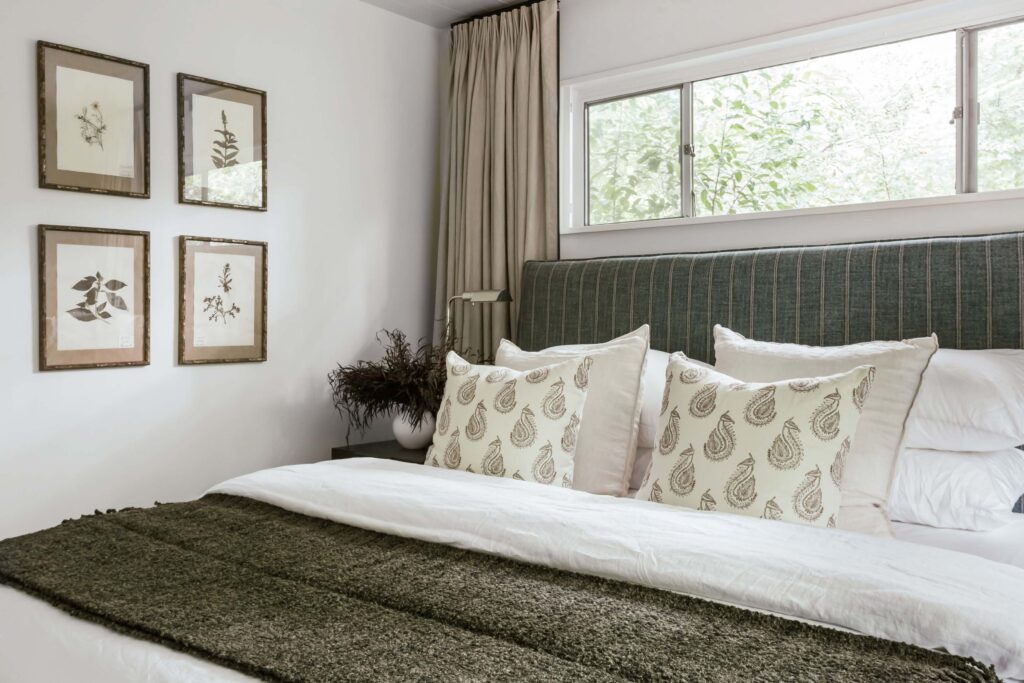 Guest room 2 close up of bed with neutral tones accent with gray-blue fabric headboard